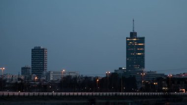 Stockholm, İsveç E18 otoyolunun gece görüşü ve Kista banliyösünün ufuk çizgisi ve kulesi.
