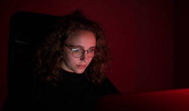 Kadın gece bilgisayar başında çalışırken bunalmış. Kırmızı ışık var..