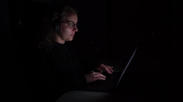 Perempuan Mengetik Laptop Malam Hari Dia Memakai Headphone Nirkabel Cahaya — Stok Video