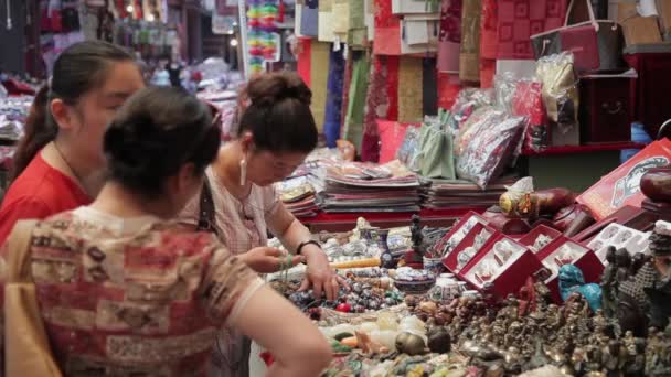 XIAN, Čína - 26. května 2012: Neidentifikovaní lidé si vybírají tradiční suvenýry na stánku v nákupní ulici Xian v Číně. — Stock video