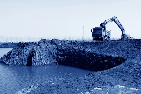 Upptagen grävmaskin på byggplatsen — Stockfoto