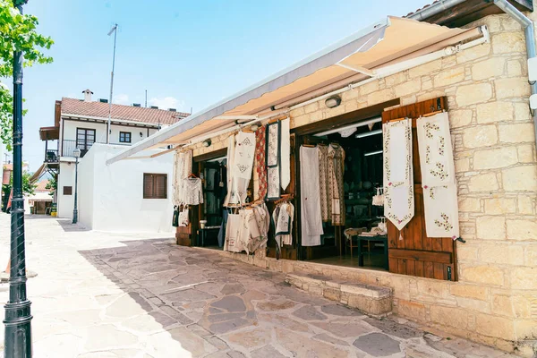 Sonnige schmale Straße mit kleinem Laden im alten Dorf Omodos auf Zypern. Steinmauern und lebendige grüne Pflanzen an einem sonnigen Tag. — Stockfoto