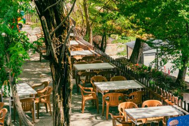 Kıbrıs 'ın Foini kentindeki dar bir sokakta açık bir kafede sandalye ve masalar. Kimse..