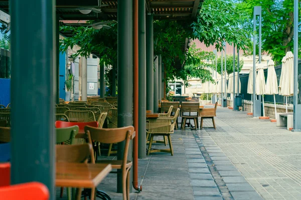 Stoelen en tafels in een terrasje in een smalle straat in Limassol, Cyprus. Niemand.. — Stockfoto