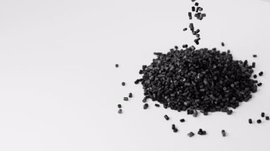 Siyah plastik polipropilen granüller bir yığın granüle dökülüyor, beyaz zemin üzerinde başyapıt polimer tahıl. HDPE veya PVC reçine topakları. 3d canlandırma canlandırması.