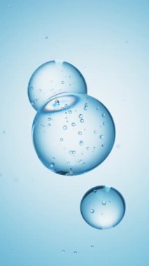 Üç damla mavi sıvı, içinde kabarcıklar olan bir sıvıya dönüşür. Deri bakım serumu damlacıkları bir araya geliyor. Kozmetik nemlendirici sıvı konsepti.