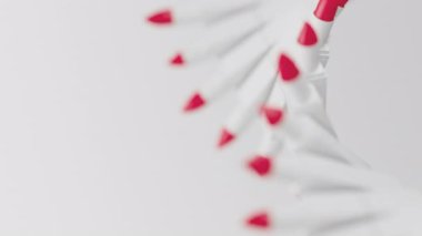 Beyaz arka planda dönen çift sıra kırmızı ruj. Sığ noktalı beyaz bir paket. Moda, kozmetik, makyaj konsepti animasyon döngüsü 3D canlandırma.