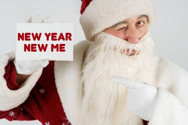 Yeni yıl ve Noel konsepti. Noel Baba 'nın elinde bir kart var. Yeni Yıl YENİ