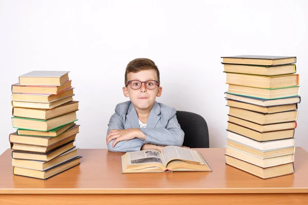 教育の概念 両側に本があるテーブルに眼鏡をかけた学生が座っている — ストック写真