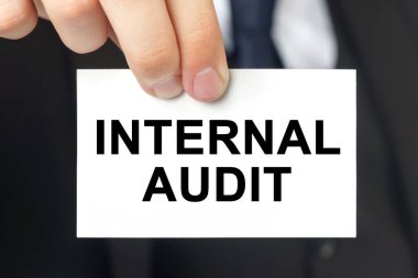 İş konsepti. İş adamı, içinde INTERNAL AUDIT yazan bir kart gösterdi