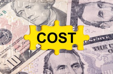 İş konsepti. Yazıtın ortasındaki doların görüntüsüyle bulmaca - Maliyet