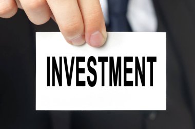 İş konsepti. İş adamı içinde INVESTMENT yazan bir kart gösterdi