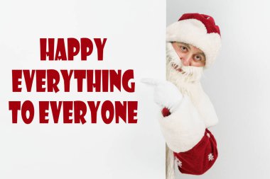 Yeni yıl ve Noel konsepti. Noel Baba parmaklarını yazı tahtasına doğrultuyor ve herkese mutlu yıllar diyor.