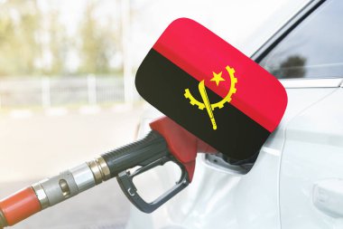 Enerji ve ekonomi kavramı. Arabanın benzin deposunda Angola bayrağı var. Depoda da benzin pompası var..