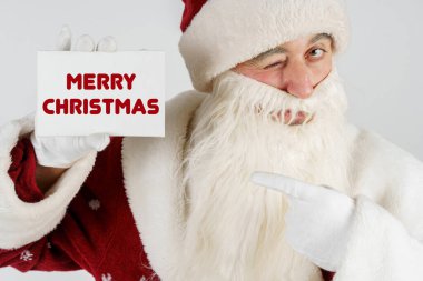 Yeni yıl ve Noel konsepti. Noel Baba 'nın elinde elinde bir kart var - Mutlu Noeller.