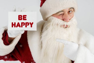 Yeni yıl ve Noel konsepti. Noel Baba elinde bir kart tutuyor - Mutlu ol.
