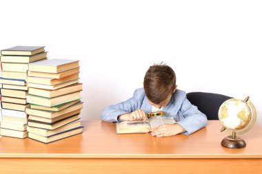 Eğitim konsepti. Öğrenci ödev yapıyor, büyüteçle kitap okuyor..