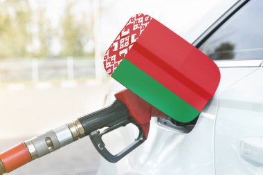 Enerji ve ekonomi kavramı. Arabanın benzin deposunda Belarus bayrağı var. Depoda da benzin pompası var..
