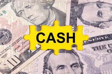 İş konsepti. Yazıtın ortasında doların görüntüsüyle bulmaca - CASH