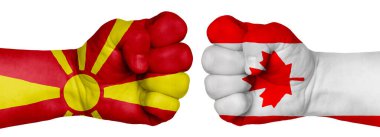 İnsanların mücadelesi kavramı. İki el birbirine kenetlenir ve birbirlerinin karşısındadır. Ülkelerin bayraklarının renklerine boyanmış eller. Kanada Makedonya 'ya Karşı