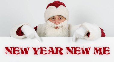 Yeni yıl ve Noel konsepti. Noel Baba parmaklarını tahtaya doğrultuyor - Yeni Yıl YENİ