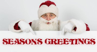 Yeni yıl ve Noel konsepti. Noel Baba parmaklarını yazı tahtasına doğrultuyor - SEASONS GREETİNGS
