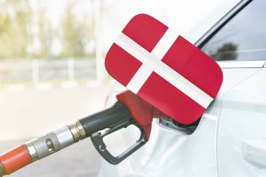 Enerji ve ekonomi kavramı. Arabanın benzin deposunda Danimarka bayrağı var. Depoda da benzin pompası var..
