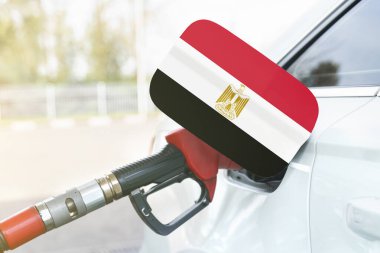 Enerji ve ekonomi kavramı. Arabanın benzin deposunda Mısır bayrağı var. Depoda da benzin pompası var..