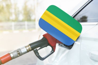 Enerji ve ekonomi kavramı. Arabanın benzin deposunda Gabon bayrağı var. Depoda da benzin pompası var..