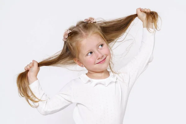 Kinderkonzept Mädchen Reicht Ihr Haar Und Lächelt Isoliert Über Weißem — Stockfoto