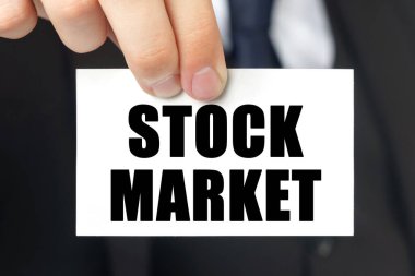 İş konsepti. İşadamı, üzerinde STOCK MARKET yazan bir kart gösterdi