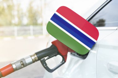 Enerji ve ekonomi kavramı. Arabanın yakıt deposunda Gambiya bayrağı var. Depoda da benzin pompası var..
