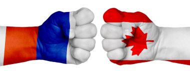 İnsanların mücadelesi kavramı. İki el birbirine kenetlenir ve birbirlerinin karşısındadır. Ülkelerin bayraklarının renklerine boyanmış eller. Kanada - Rusya