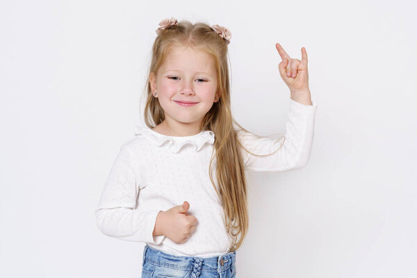 ChiChildren concept. The girl shows a hand gesture. Isolated over white background.