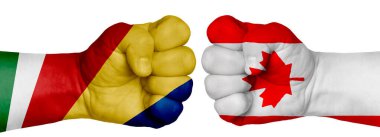 İnsanların mücadelesi kavramı. İki el birbirine kenetlenir ve birbirlerinin karşısındadır. Ülkelerin bayraklarının renklerine boyanmış eller. Kanada Seyşeller 'e Karşı