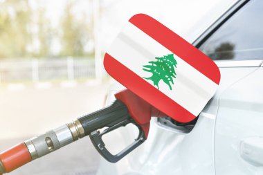 Enerji ve ekonomi kavramı. Arabanın benzin deposunda Lübnan bayrağı var. Depoda da benzin pompası var..