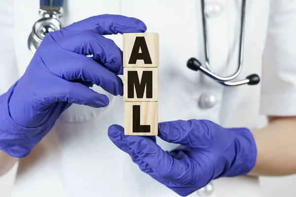 Tıp ve sağlık konsepti. Doktor, küpleri üzerinde AML yazan ellerinin içinde tutuyor. Akut Myeloid Lösemi