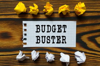 İş ve finans kavramı. Ahşap bir tahtanın üzerinde buruşmuş kağıt yaprakları ve üzerine bütçe büstü yazıldığı bir defterden bir yaprak var.