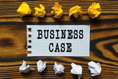 İş ve finans kavramı. Ahşap bir tahtanın üzerinde buruşmuş kağıt yaprakları ve üzerine yazıldığı bir defterden bir yaprak var.