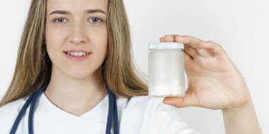 Tıp ve sağlık konsepti. Doktor kadın hapları elinde tutuyor. Beyaz arkaplanda izole.