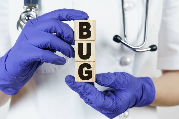 Medicine and health concept. The doctor holds cubes in his hands on which it is written - BUG