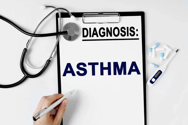 医学和健康概念 桌上有听诊器 药丸温度计和诊断单 文本写在诊断页上 Asthma — 图库照片
