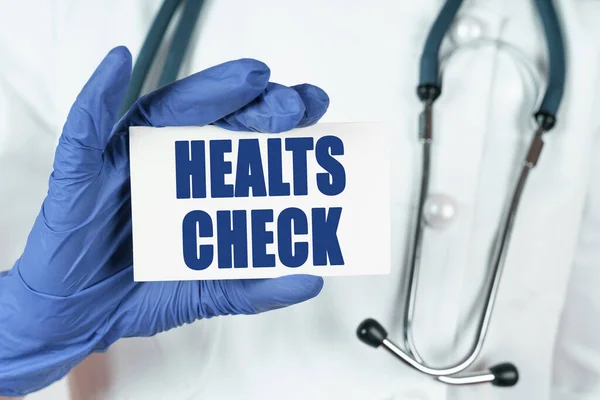 Medicine concept. The doctor holds a business card that says - HEALTS CHECK