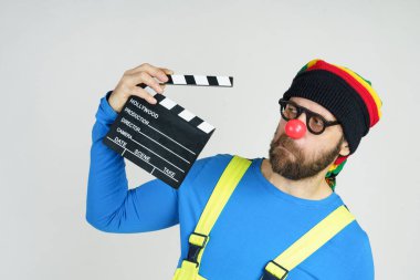 Espri ve eğlence anlayışı. Parlak takım elbiseli bir palyaço elinde bir film klasörü tutuyor..