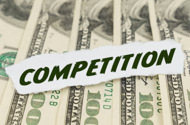 İş ve finans kavramı. Dolarların arka planında, üzerinde COMPETITION yazan bir kağıt parçası yatıyor.