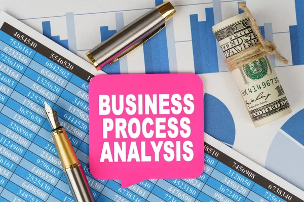 Business and finance concept. Among the financial statements and charts is a note with the text - BUSINESS PROCESS ANALYSIS