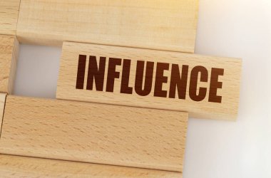 İş ve finans kavramı. Masanın üzerinde tahta bir Jenga var, bir Jenga 'nın üzerine yazılmış - INFUENCE