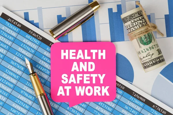 Business and finance concept. Among the financial statements and charts is a note with the text - HEALTH AND SAFETY AT WORK