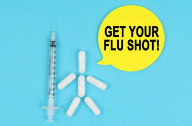 Tıp ve sağlık konsepti. Şırınga, haplardan yapılmış insan figürü ve üzerinde yazı olan kağıt yapıştırıcı.