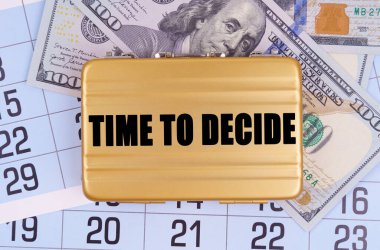 İş ve finans. Masanın üzerinde bir takvim, para ve üzerinde yazı olan bir evrak çantası var.